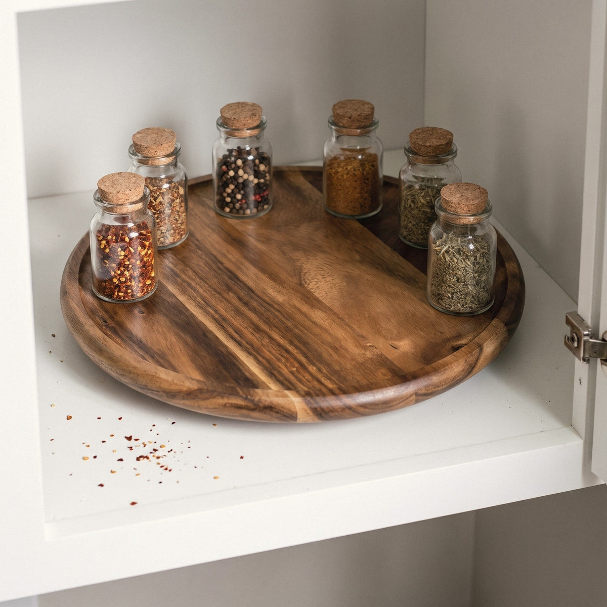 Acacia lazy susan with spice jars in a kitchen cabinet