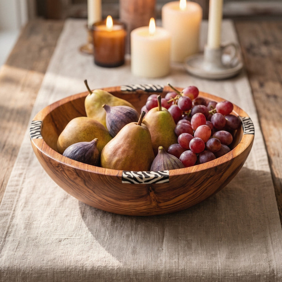 Olive wood serving bowl with pears, figs and grapes on a wooden table