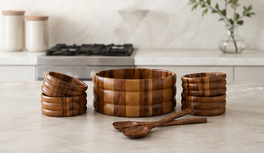 7-piece acacia salad bowl set on a kitchen counter in front of the stove