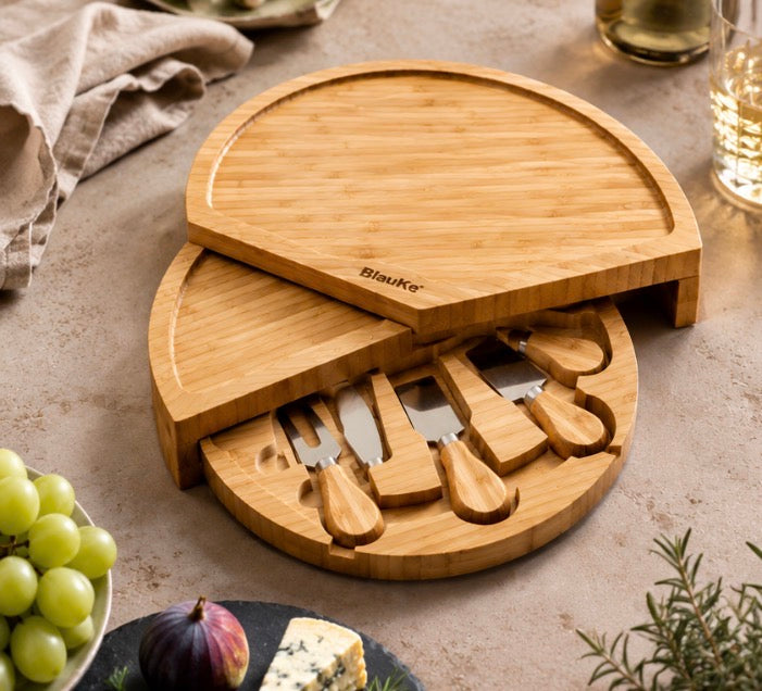 Swiveling bamboo cheese board with four cheese knives in the slide-out drawer