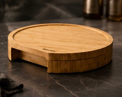 Bamboo cheese board closed, showing the drawer below the top, on a dark marble counter