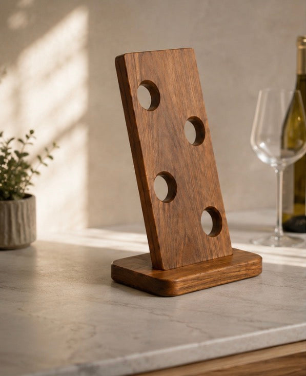 Acacia wine bottle holder on a stone countertop beside a glass and a bottle of white wine