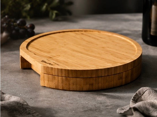 Round bamboo cheese board closed, on a dark stone counter