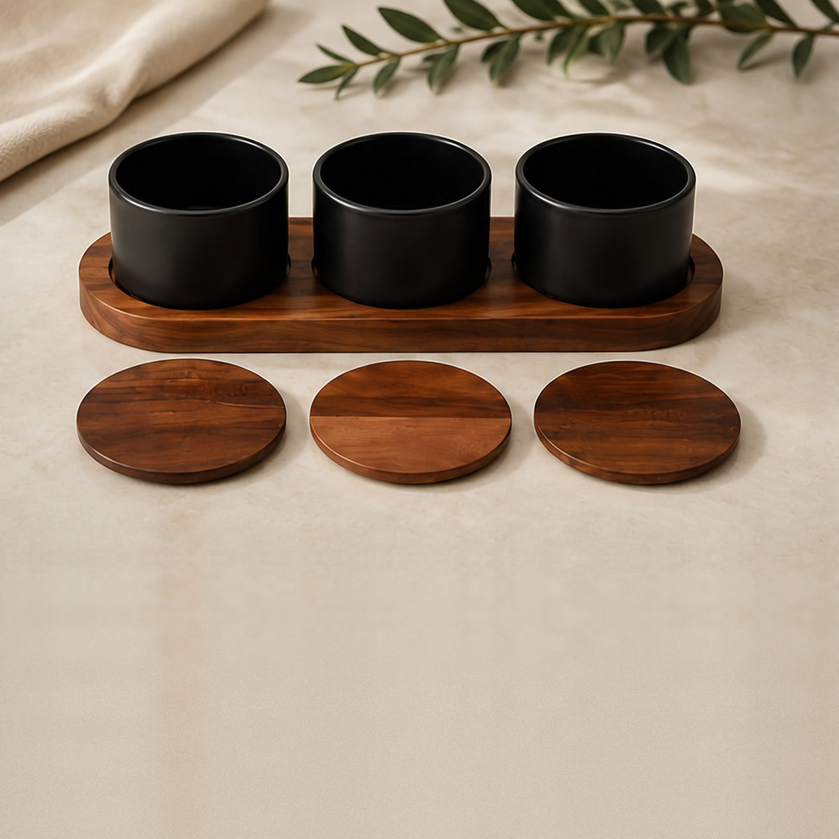 Three black ceramic dishes in an acacia wood base with their round acacia lids laid in front