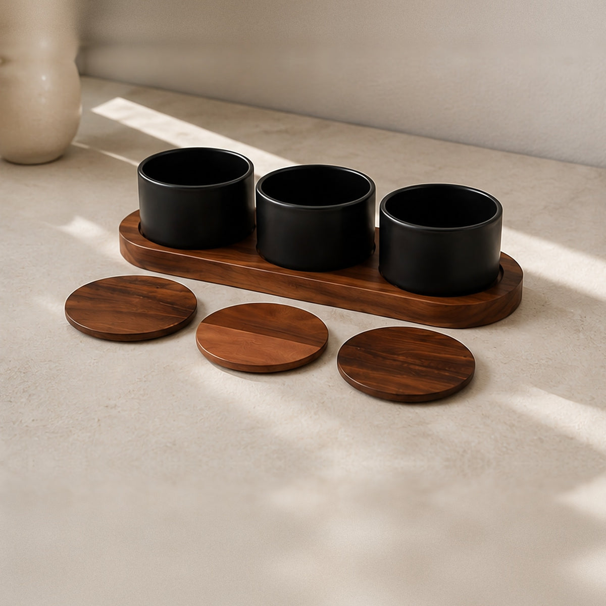 Ceramic and acacia condiment set in warm window light on a stone counter