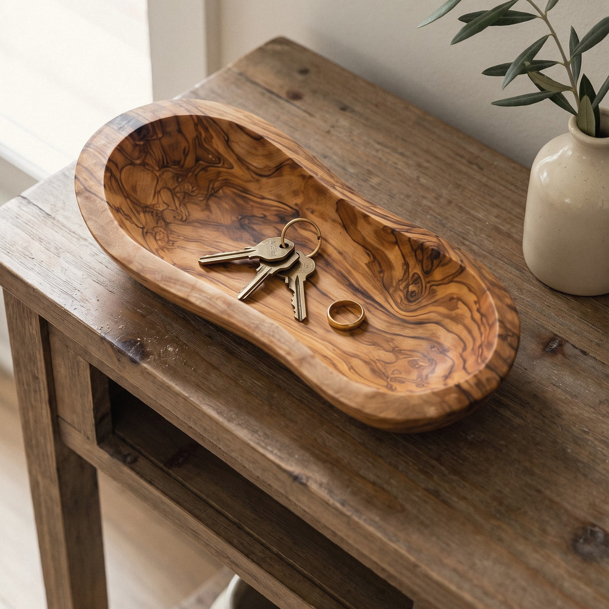 Live edge olive wood bowl holding keys on an entryway console