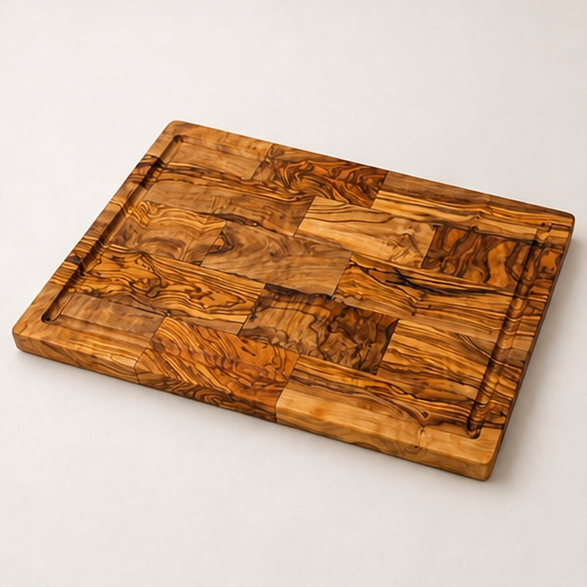 Large olive wood cutting board seen at an angle, with a juice groove running around the edge