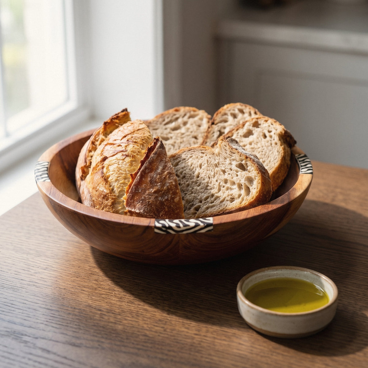 Hand-carved olive wood serving bowl with sliced rustic bread